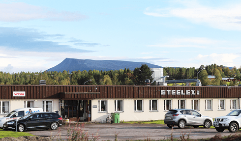 The Steelex office building with a parking lot in front and scenic nature in the background.